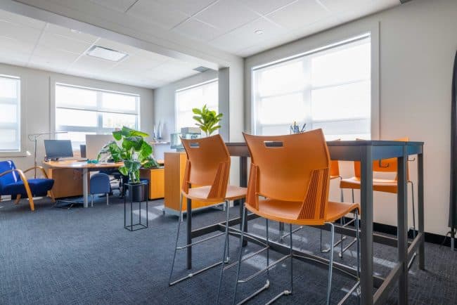 Bureau loft avec de grandes fenêtres, table de travail et poste de travail